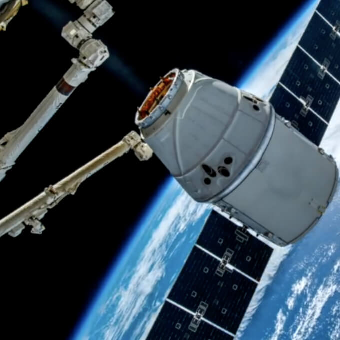 SpaceX Dragon spacecraft docking with the International Space Station above Earth.